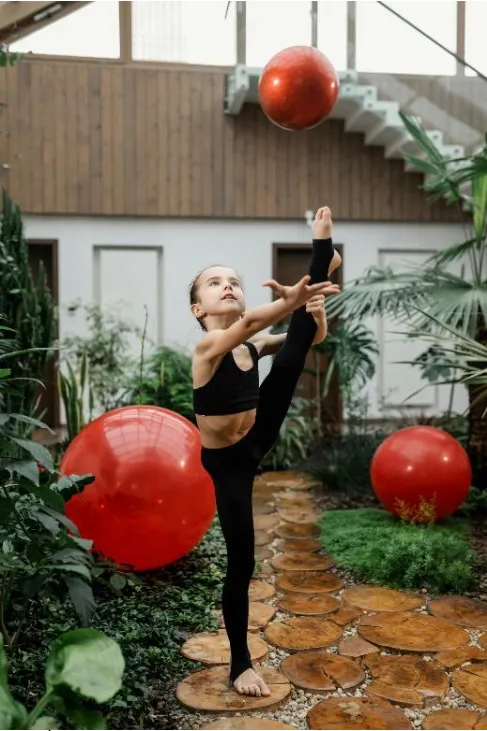 Imagen de niña practicando balet en un patio.